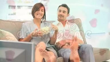 一对夫妇在沙发上吃玉米片，上面有粉红色的心动画